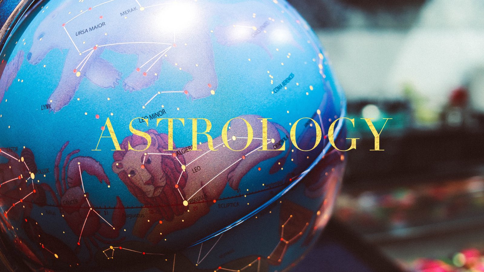 Bright blue globe with a blurred background with the Leo and Leo Minor constellations on the front with the word "astrology" in all caps in gold on the foreground.
